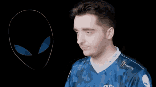 a man wearing a blue shirt that says team liquid adjusts his headphones