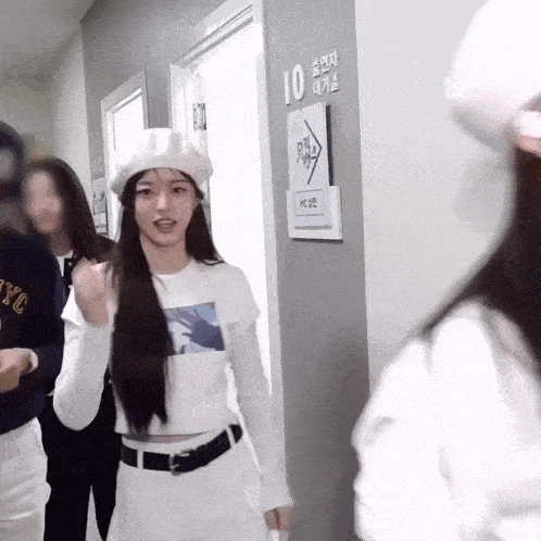 a woman wearing a white hat is standing in a hallway with a sign that says 10 on it