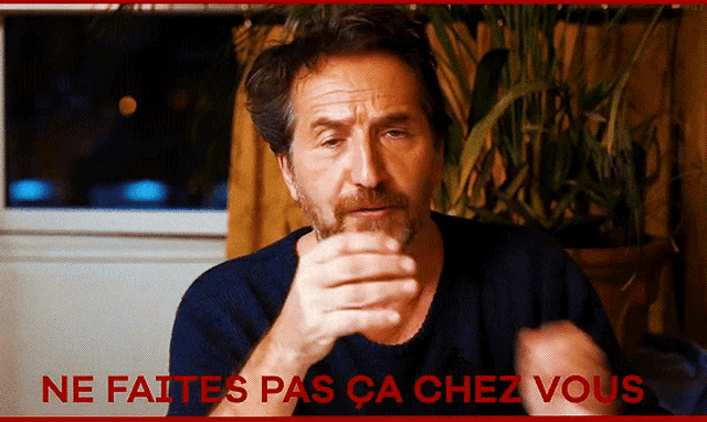 a man with a beard is making a gesture with the words ne faites pas ca chez vous above him