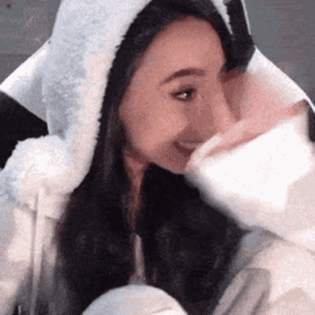 a close up of a woman wearing a furry hooded jacket