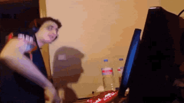 a man wearing headphones is standing in front of a computer screen