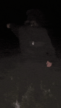 a person is laying on the ground in the dark looking at something .