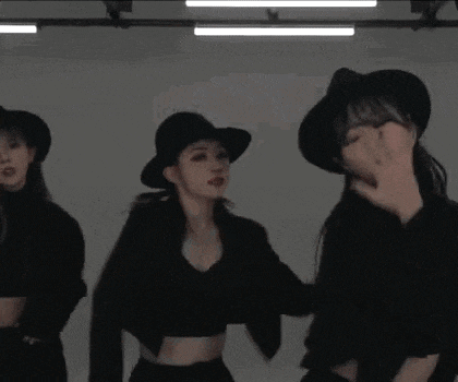a woman wearing a black hat and a black jacket is dancing .