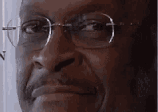 a close up of a man 's face with glasses on .