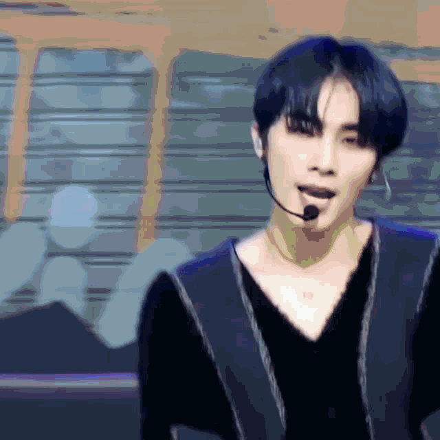 a man wearing a black shirt and a microphone on his neck