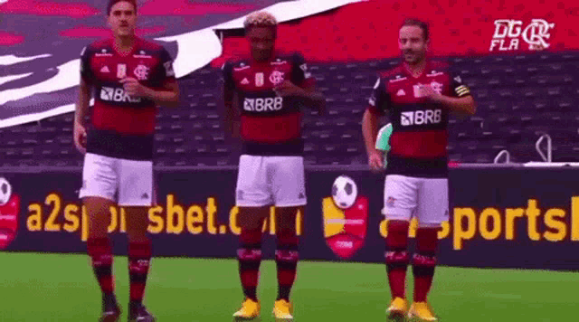a group of soccer players are standing on a field in front of a sports advertisement .