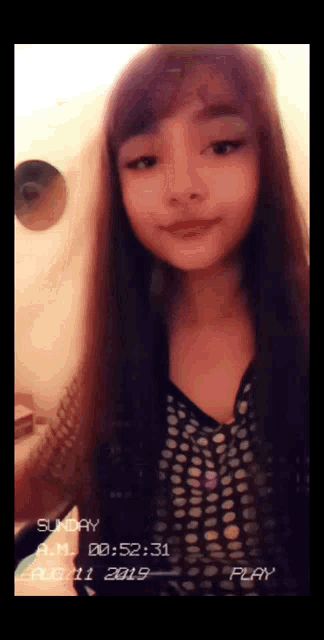 a girl with long hair is wearing a polka dot shirt