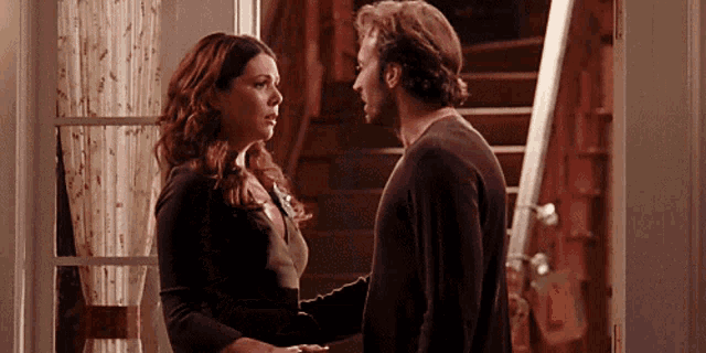 a man and a woman are looking at each other in a doorway