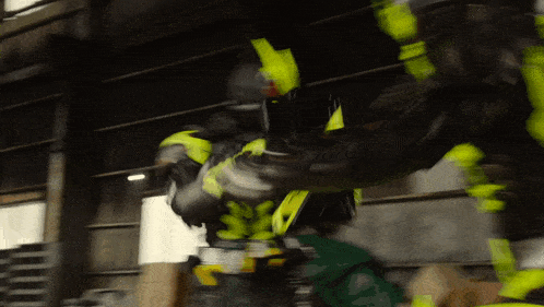 a blurred image of a person wearing a black and yellow suit