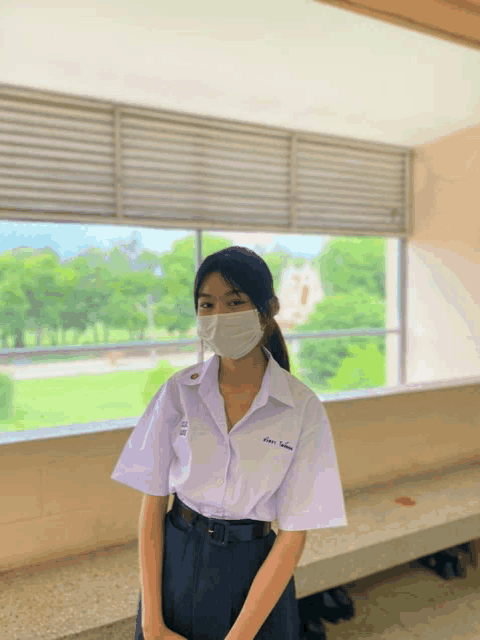 a girl wearing a mask and a shirt that says ' a ' on the front