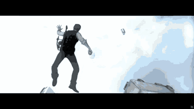 a man in a black vest is jumping in the air