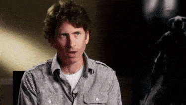 a man in a plaid shirt has a microphone in his pocket