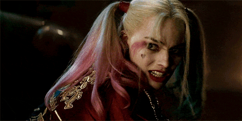 harley quinn from suicide squad is smiling and looking at the camera .