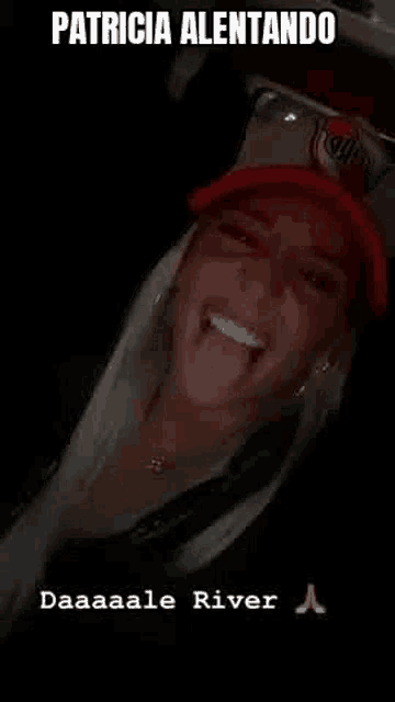 a woman is sticking her tongue out while wearing a red hat .