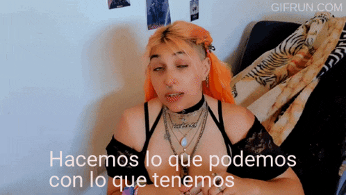 a woman with red hair is sitting on a bed with the words hacemos lo que podemos con lo que tenemos