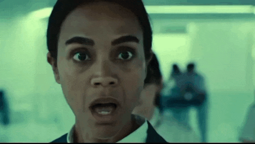 a close up of a woman 's face with her mouth open in a hallway .