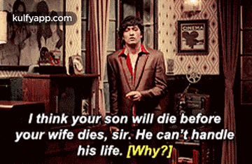 a man in a suit is standing in a living room talking to a woman .
