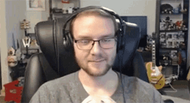 a man wearing glasses and headphones is sitting in a chair in a room .