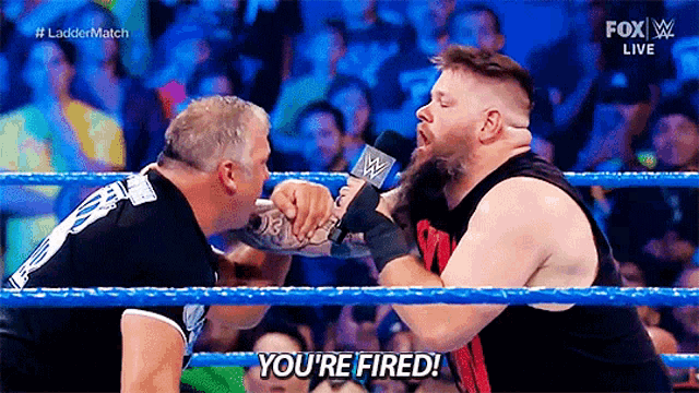 two men are wrestling in a ring and one of them is saying you 're fired
