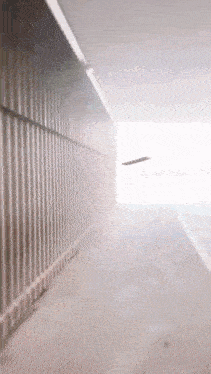 a plane is flying through a tunnel with a fence