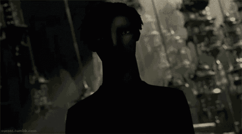 a black and white photo of a man 's face in the dark