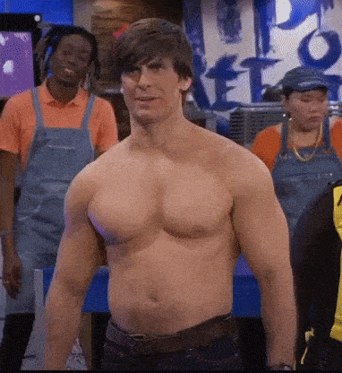 a shirtless man is standing in front of a group of people wearing overalls