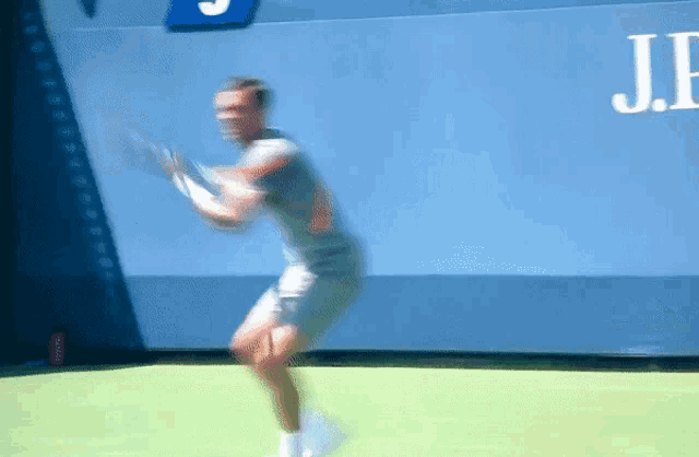 a blurry image of a tennis player with a j.p. logo in the background