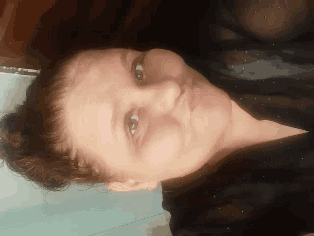 a close up of a woman 's face with a bun