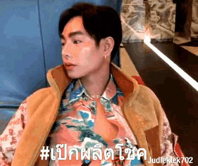 a man wearing a floral shirt and a tan vest says # judieklek702
