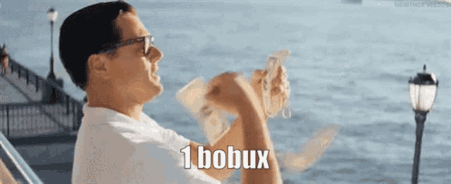 a man is holding a bunch of money in his hands and says 1 bobux