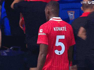 a man wearing a red jersey with the number 5 on the back