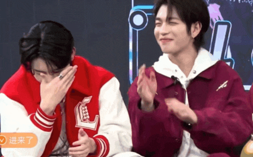 two young men wearing varsity jackets with the letter l on them