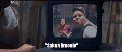 a tv screen shows a man and a woman and the words " saluta antonio " on the bottom