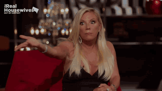 a woman sitting in a red chair with the words real housewives out of context on the bottom