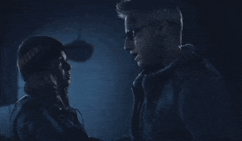 a man and a woman are looking into each other 's eyes in a dark room