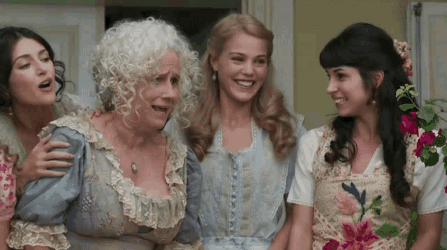 a group of women are posing for a picture and one of them is wearing a floral shirt