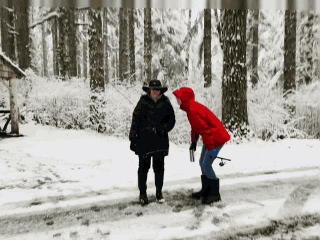 a woman in a red jacket stands next to another woman in a black coat