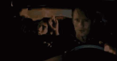 a group of people are sitting in a car at night and a woman is driving .