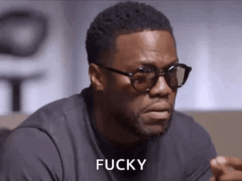a man wearing glasses and a black shirt is making a face and saying fucky .