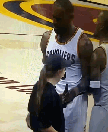 a man wearing a cavaliers jersey talks to a boy
