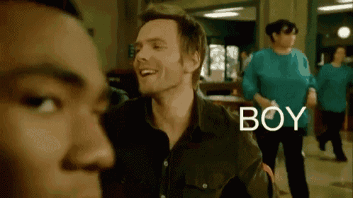 a man in a black shirt is smiling and the word boy is next to him
