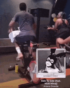 a man riding an exercise bike with a picture of ariana grande on the screen