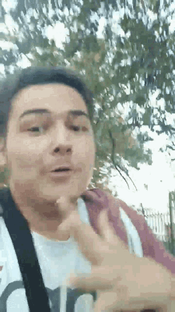 a man wearing a white shirt and a red jacket is making a funny face