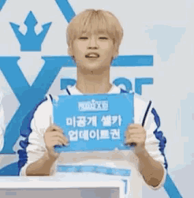 a young man is holding a sign that says ' x ' on it .
