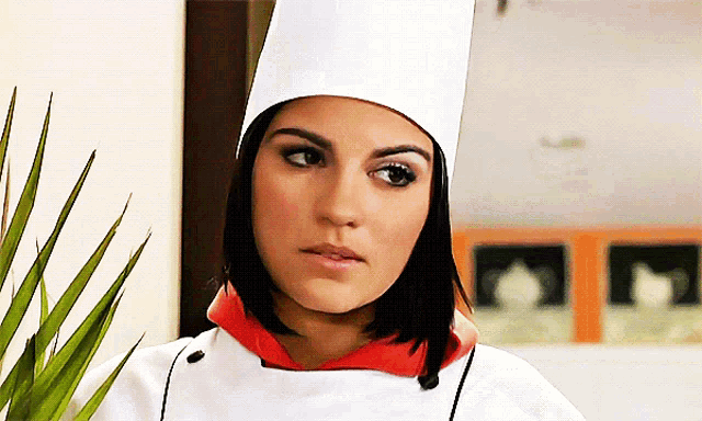 a woman wearing a chef 's hat and a white jacket