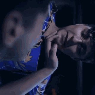 a man in a blue shirt is looking down