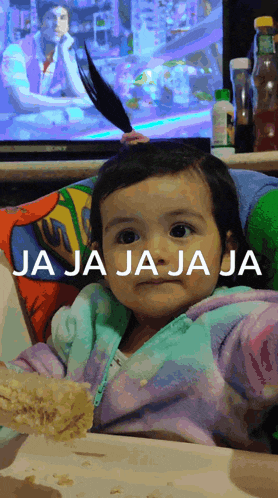 a little girl sitting in front of a television with the words " ja ja ja ja " written on her face