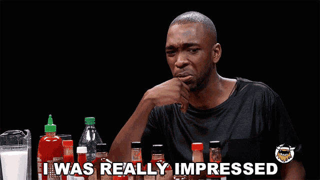 a man sits in front of bottles of hot sauce and says i was really impressed