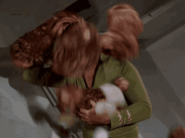 a man in a green shirt is surrounded by a bunch of stuffed animals