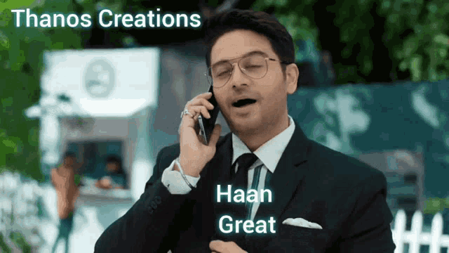 a man in a suit talking on a cell phone with the words thanos creations written above him